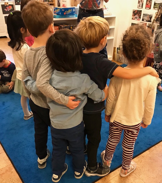 children with their arms around eachother