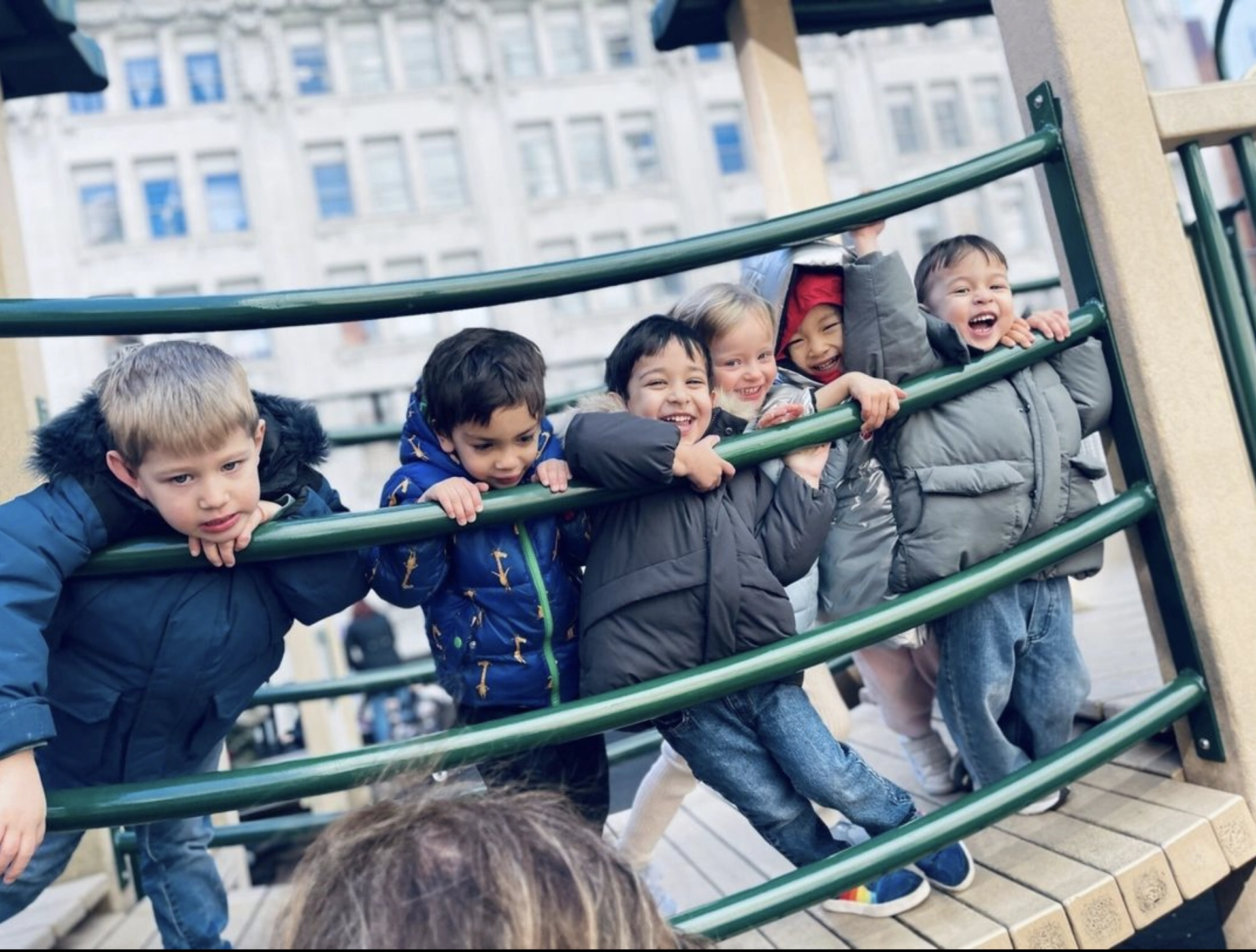 kids hanging on playground bridge