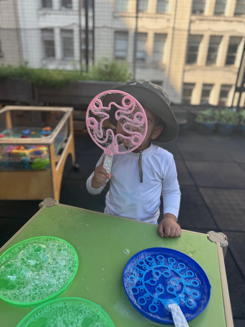 a child blowing bubbles on rooftop