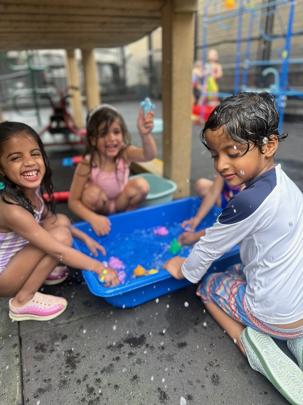 children playing with water in a bucket